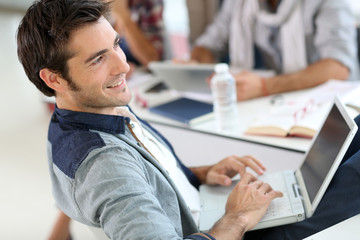 Student in campus relaxing with laptop