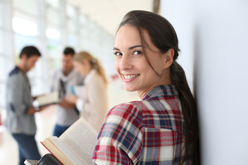 Smiling student girl standing in hall