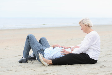 Fototapeta na wymiar Senior loving couple relaxing on the beach