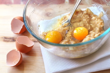 Mix of banana and eggs in a glass bowl