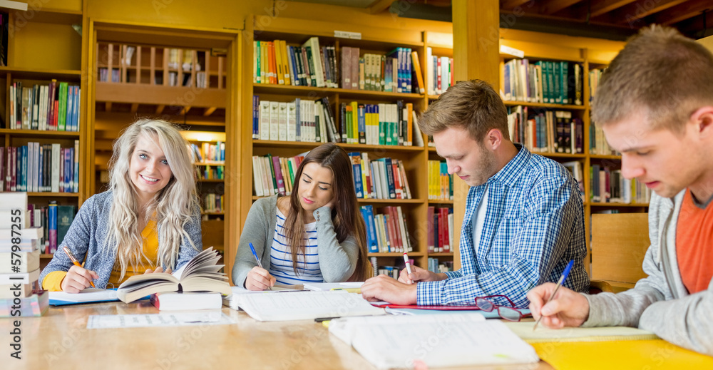 Poster group of students writing notes at library desk