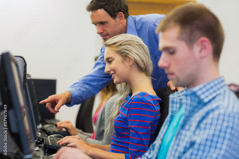 Poster Teacher showing something on screen to student in computer room
