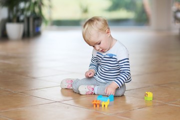 Cute little baby girl play with plastic bricks