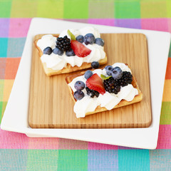 Waffles and fresh seasonal fruits with whipped cream