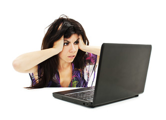 Stressful young woman working on laptop on white background