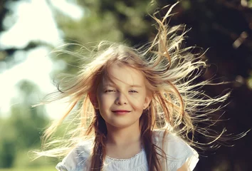 Fotobehang Hair of pretty little girl hair is blowing in the wind © jahmaica