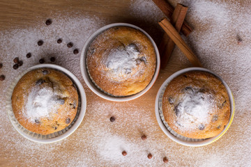 Three muffins with icing sugar