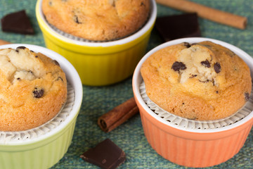 Three muffins with cinnamon sticks and chocolate