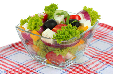 Greek salad on plate on table on white background
