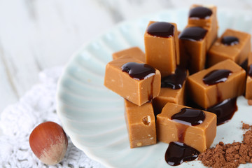 Many toffee on plate on napkin on wooden table