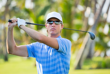 Athletic young man playing golf