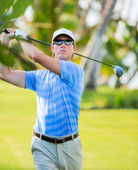 Athletic young man playing golf