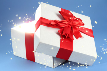 Gift box with bright light on it on blue background