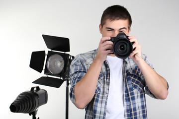 Handsome photographer with camera, on photo studio background