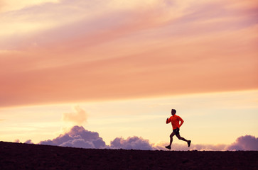 Male runner silhouette, running into sunset