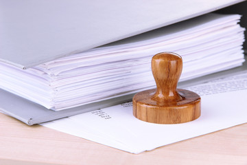 Wooden stamp and papers on table