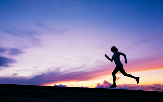 Female runner silhouette, running into sunset