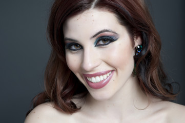 A young happy female model headshot in a studio.