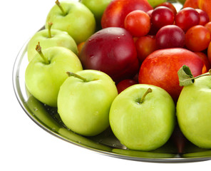 Assortment of juicy fruits on plate, isolated on white