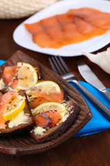 Salmon sandwiches on plate  on wooden table close-up