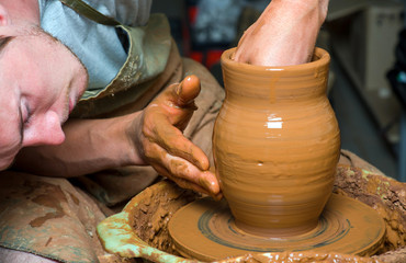 hands of a potter, creating an earthen jar on the circle