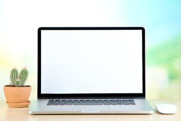 Fototapeta premium Laptop and cactus in flowerpot on wooden table