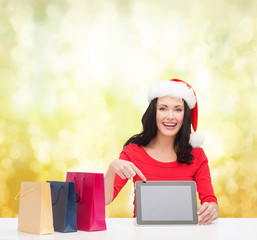 woman in santa helper hat with tablet pc