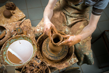 hands of a potter, creating an earthen jar on the circle