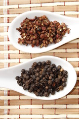 szechuan and black pepper on white ceramic spoon