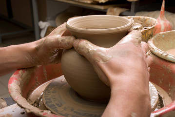 hands of a potter, creating an earthen jar on the circle