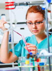 female tech or scientist works with pipette in biological labora