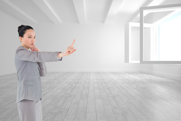 Composite image of thoughtful asian businesswoman pointing