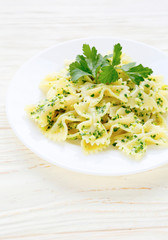farfalle pasta with pesto on white plate