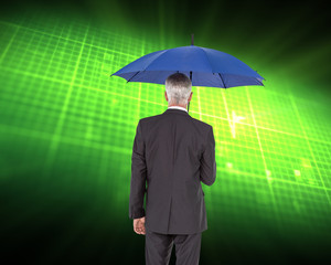 Composite image of businessman holding umbrella