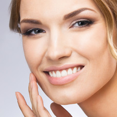 Obraz premium Woman touching skin or applying cream, on grey