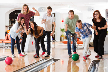 Young Friends Bowling While People Cheering