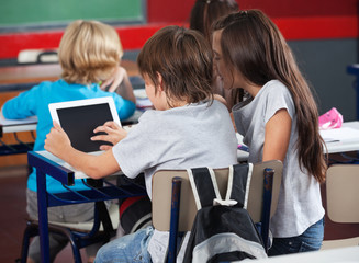 Schoolchildren Using Digital Tablet In Classroom