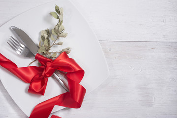 Festive table setting and decoration with red ribbon