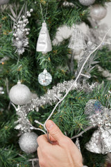 Man Decorating Christmas Tree With Fairy Lights