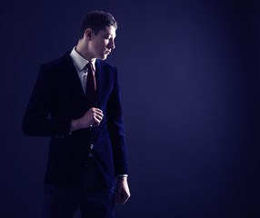 Stylish young man in a blue suit and red tie.