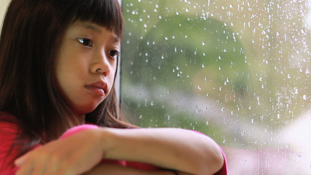 Little Asian Girl Depressed On A Rainy Day