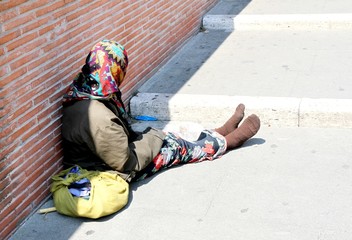 Gypsy with lurid clothes while begging on the street