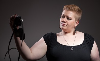 Chubby woman taking pictures of old camera