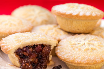 Sweet and spicy Christmas mince pies stacked on white plate. Clo