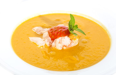 Pumpkin soup with shrimp and tomato on a white background