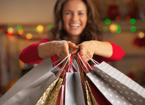 Closeup on christmas shopping bags in hand of smiling woman