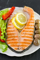 salmon with lemon, salad and olives