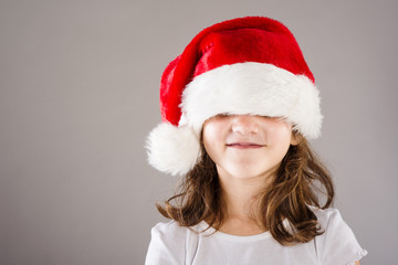Small girl in santa hat with christmas gift