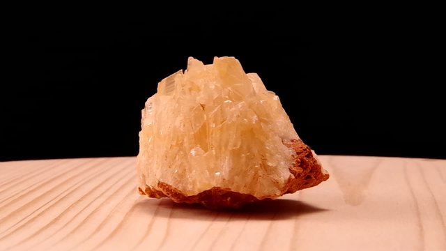 Calcit raw mineral stone revolves on the board