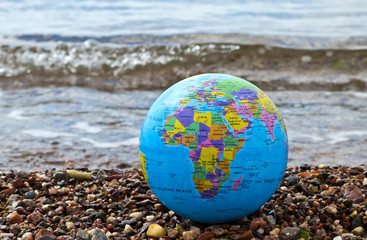 A color globe of earth on marine beach
